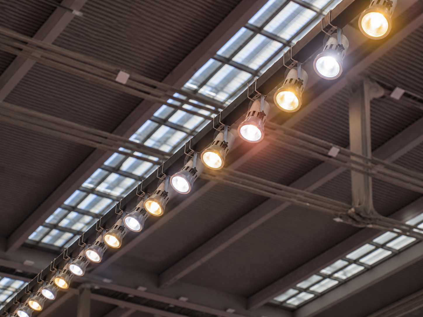 Row of commercial track lighting installed on a warehouse ceiling
